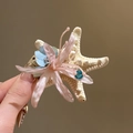 Makroansicht der zarten rosa Spinnenlilie und des Seestern-Details auf dieser retro Haarspange - Seestern Spinnenlilie-Stil / Rosa