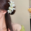 Detaillierte Seitenansicht eines Modells mit eleganten weißen Spinnenlilien-Haarspangen - Acryl Spinnenlilie Haarnadel-Stil (28#) / Gold-Grün