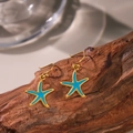 Boucles d'oreilles étoile de mer dorées avec émail bleu ciel sur fond en bois - Boucles d'Oreilles Étoile de Mer Bleue (QYG279) / Or