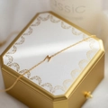 Collier élégant en titane doré avec pendentif lettre M présenté sur un coffret cadeau - Doré