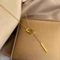 Elegant gold titanium steel necklace featuring a G-shaped pendant with a sleek metal bar - Interlocking Loops (H186) / Gold