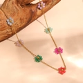 Detail shot of a gold chain necklace with colorful bead flowers on natural wood background. - Colorful Transparent Flower Bead Necklace