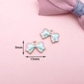 Détail macro de breloques nœud en émail bleu clair avec dimensions 15mm x 9mm - Pendentif Nœud Papillon (C-221) / Bleu clair
