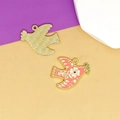 Close-up of pink enamel dove bird charms with floral patterns and textured gold back - White Flower Peace Dove
