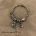 Silver beaded bracelet featuring a light blue resin bear and Saturn planet pendant charms - Exquisite Beaded Style (B1079)
