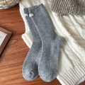 Calze di lana grigia a costine con etichetta bianca su sfondo in maglia beige - Grigio Medio con Etichetta