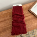 Y2K dark red knitted leg warmers with cable stitch pattern on wooden surface - Red