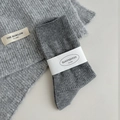 Medium gray textured knit crew socks with ribbed pattern and classic paper band packaging - One Size / Light Gray