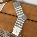 Chaussettes en laine à rayures gris et beige avec tricot torsadé sur fond en bois rustique - Taille unique / Gris clair