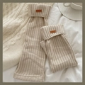 Jambières en tricot blanc crème avec écusson en cuir sur literie blanche douce - Taille unique / Beige
