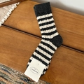 Chaussettes en laine d'hiver à rayures gris foncé et beige sur fond en bois chaleureux - Taille unique / Gris clair