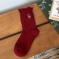 Calcetines navideños rojo oscuro con reno bordado sobre superficie de madera - Reno Rojo