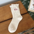 Creamy white Christmas mid-calf socks with red Merry Christmas embroidery on wood surface - Cream Merry Christmas