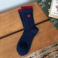 Dark blue Christmas socks with red trim and festive embroidery on wooden background - Navy Blue Apple