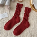 Calcetines de lana roja para mujer con diseño acanalado en un ambiente hogareño acogedor - Burbuja