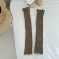 Brown knitted leg warmers with ribbed texture and ruffle trim on a white bed - One Size / Khaki
