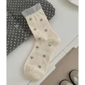 Mid-calf cream and grey star pattern cotton socks shown in a minimalist flat lay setting - Blue Star