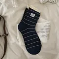 Dunkelblaue gestreifte Baumwollsocken mit Panda-Patch und Wellensaum auf Laken - Einheitsgröße / Schwarz
