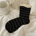 Black and white striped crew socks with cream ruffled cuffs in soft cotton material - Black