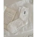 White crew socks with grey polka dots, blue bear embroidery, and ruffled lace cuffs - White