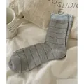 Grey striped crew socks with light blue ruffled cuffs in a cozy lifestyle setting - Light Gray