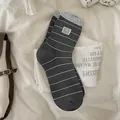 Dark grey striped panda socks with light blue ruffle edge in a cozy display - One Size / Dark Gray