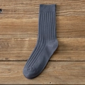 Calcetines de algodón gris oscuro con punto acanalado para hombre sobre fondo de madera - Talla única / Gris