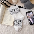White crew socks featuring black terrier jacquard patterns in a cozy home setting - White
