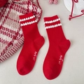 Festliche rote Socken mit weißen Plüschbällen und 'in good' Textstickerei - Plüschball Dekor Stil
