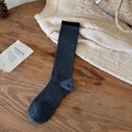 Calze di lana grigio scuro con bordo nero a contrasto su sfondo in legno caldo - Taglia unica / grigio scuro