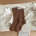 Brown cable knit socks with colorful speckles and vertical ribbed texture on gray fabric - Brown