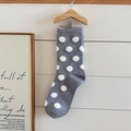Grey mid-calf socks with white polka dots and 3D pom-pom hanging on a wooden wall - One Size / Polka Dot Style