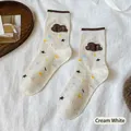 Cream white crew socks featuring plush cloud applique and colorful star patterns - Creamy White