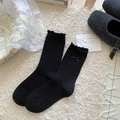 Calze nere stile balletto con fiocchi e bordi a volant su tappeto di peluche - Ornamento Fiocco a Pois Nero