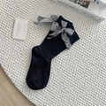 Black rib-knit mid-calf socks with black and white checkered bow tie accent - One Size / Black