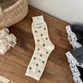 Beige mid-calf socks with black bow patterns and ruffled edges in vintage style - Milky White Small Bow