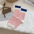 Calze a righe rosse e bianche con polsini blu a contrasto su un letto morbido - Taglia unica / Bianco a Righe Rosse