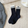 Calze nere a costine con strisce grigie ed etichetta del marchio su tappeto beige - Nero