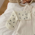 Cream white mid-calf socks featuring black bow patterns and soft cotton knit texture - Milky White Small Bow