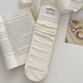 Beige cotton crew socks with lace trim and 3D floral patterns on a minimal background - Soft White