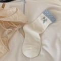 Cream crew socks featuring blue polka dot cuffs and delicate bows in a flat lay style - White Blue Bow