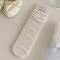 White knit crew socks with hollow bow pattern and ruffled trim in original packaging - Ice Cream White
