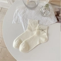Cream-colored ribbed socks with delicate silver bow accents and minimalist ballet style - Off White
