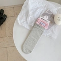 Chaussettes grises côtelées avec dentelle à carreaux rose sur une table blanche - Bord Rose Gris