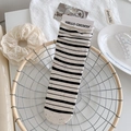Black and white striped crew socks with colorful speckle texture in retail packaging - Black Stripe