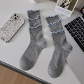 Calze grigie a coste con bordi arricciati azzurri in un moderno set fotografico flat lay - Taglia unica / Grigio