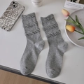 Grey knit slouch socks with ruffled texture shown with stylish minimalist props - One Size / Gray