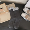 Dark gray mid-calf socks with silver sequins on a dark wooden table with pearl accents - One Size / Gray
