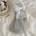Light grey crew socks featuring white lace trim and bow decorations on a white sheet - One Size / Light Gray