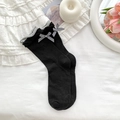 Black crew socks featuring grey ruffle trim and black-and-white plaid bow details - Black